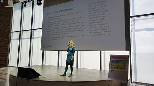 One person standing on a stage with a microphone in hand to give a presentation.  