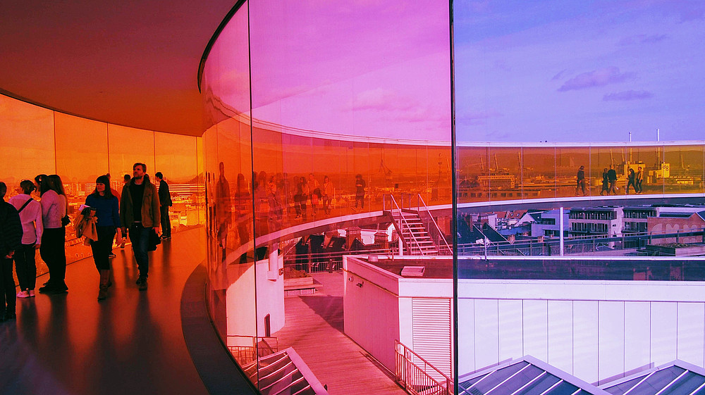 People walking through a colourful glass installation.  © Image: Matt Morelli