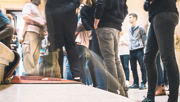  Close up of people's legs and feet as they walk up a staircase.