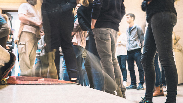  Close up of people's legs and feet as they walk up a staircase.