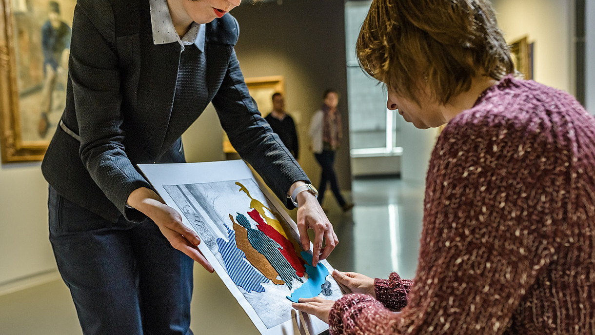 © Royal Museums of Fine Arts of Belgium_Fin de Siecle Museum_visit.brussels, Image: Jean-Paul Remy A blind person is feeling a replica of a painting. The different elements of the painting are made from different kinds of materials.