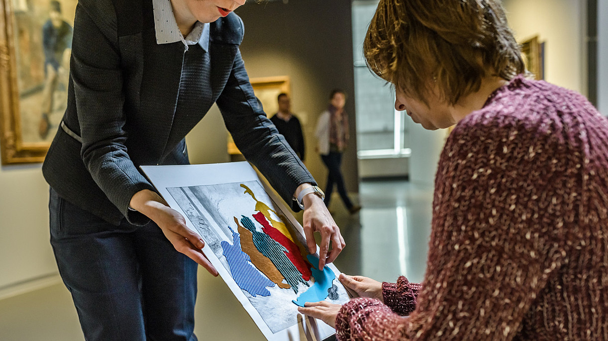 © Royal Museums of Fine Arts of Belgium_Fin de Siecle Museum_visit.brussels, Image: Jean-Paul Remy A blind person is feeling a replica of a painting. The different elements of the painting are made from different kinds of materials.