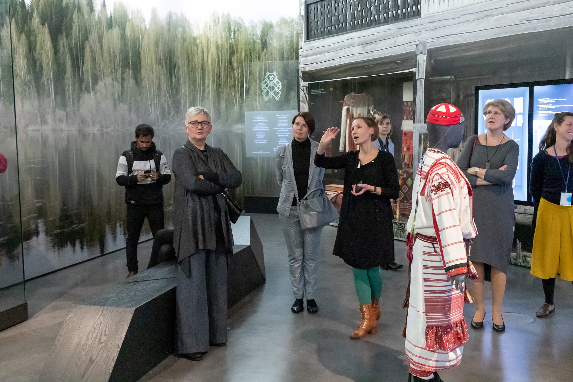 A museum guide points at something outside the picture and explains it.   © Image: Arp Karm