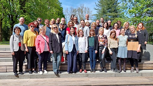 Group photo of about 20 people standing on steps, looking into the camera.  