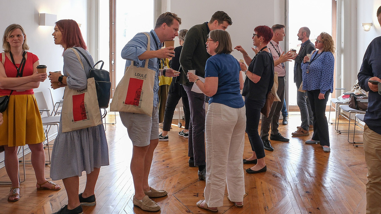 © Image: Jorge Gomes Numerous people are standing in groups and talking to each other.