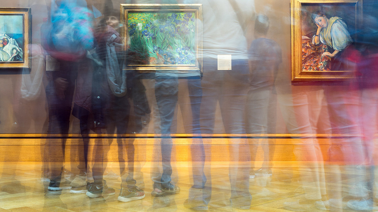 © Image: Sergei Akulich The photographer has used the slow shutter function so that it looks like several people are moving quickly in front of a wall with three pictures on it.
