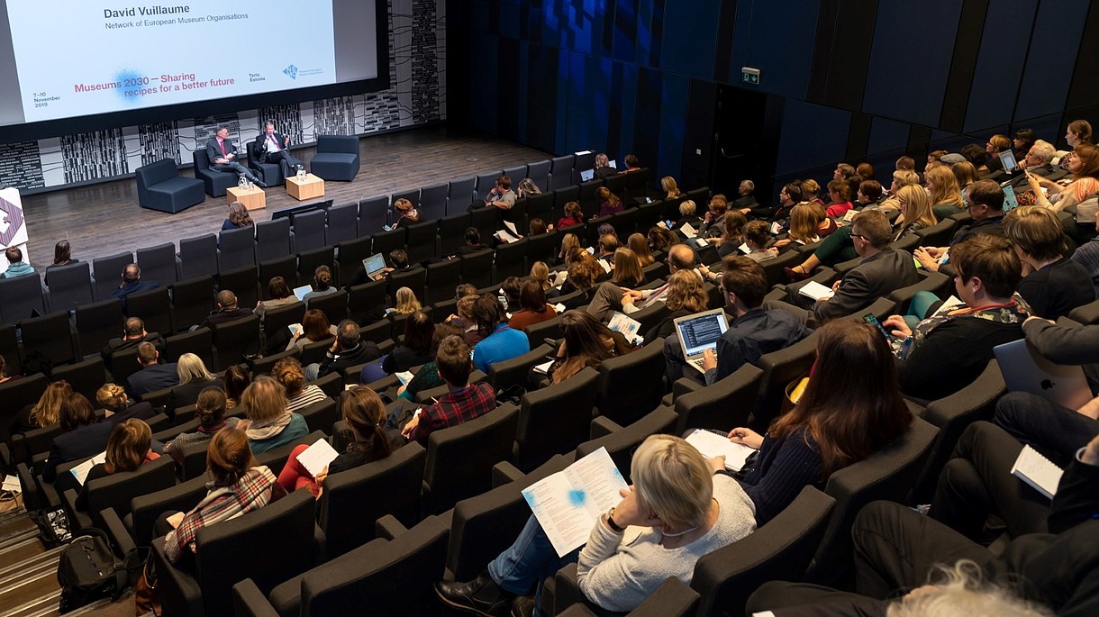 © Image: Arp Karm Auditorium full of people looking at two people on the stage. A sign shows that they are discussing EU culture policy. 