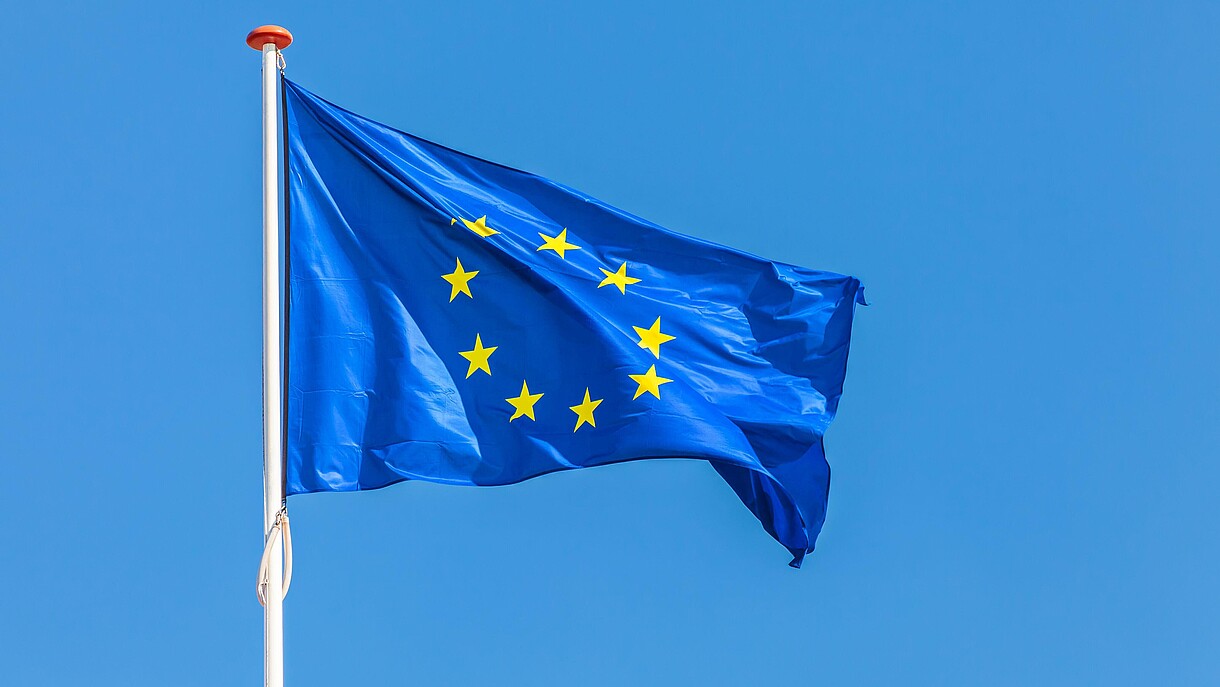 © Martin Bergsma / Alamy Stock Foto The European flag waving in front of a clear blue sky.
