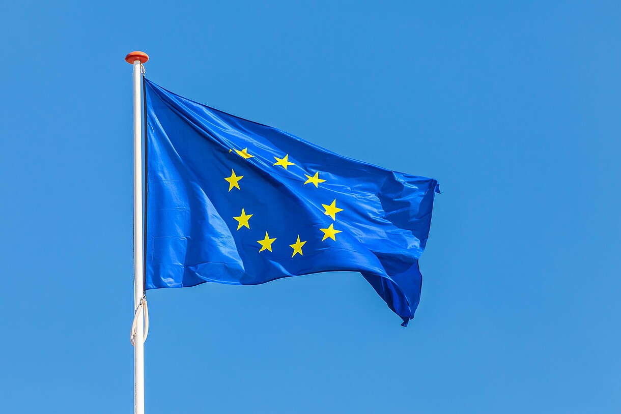 © Martin Bergsma / Alamy Stock Foto The European flag waving in front of a clear blue sky.