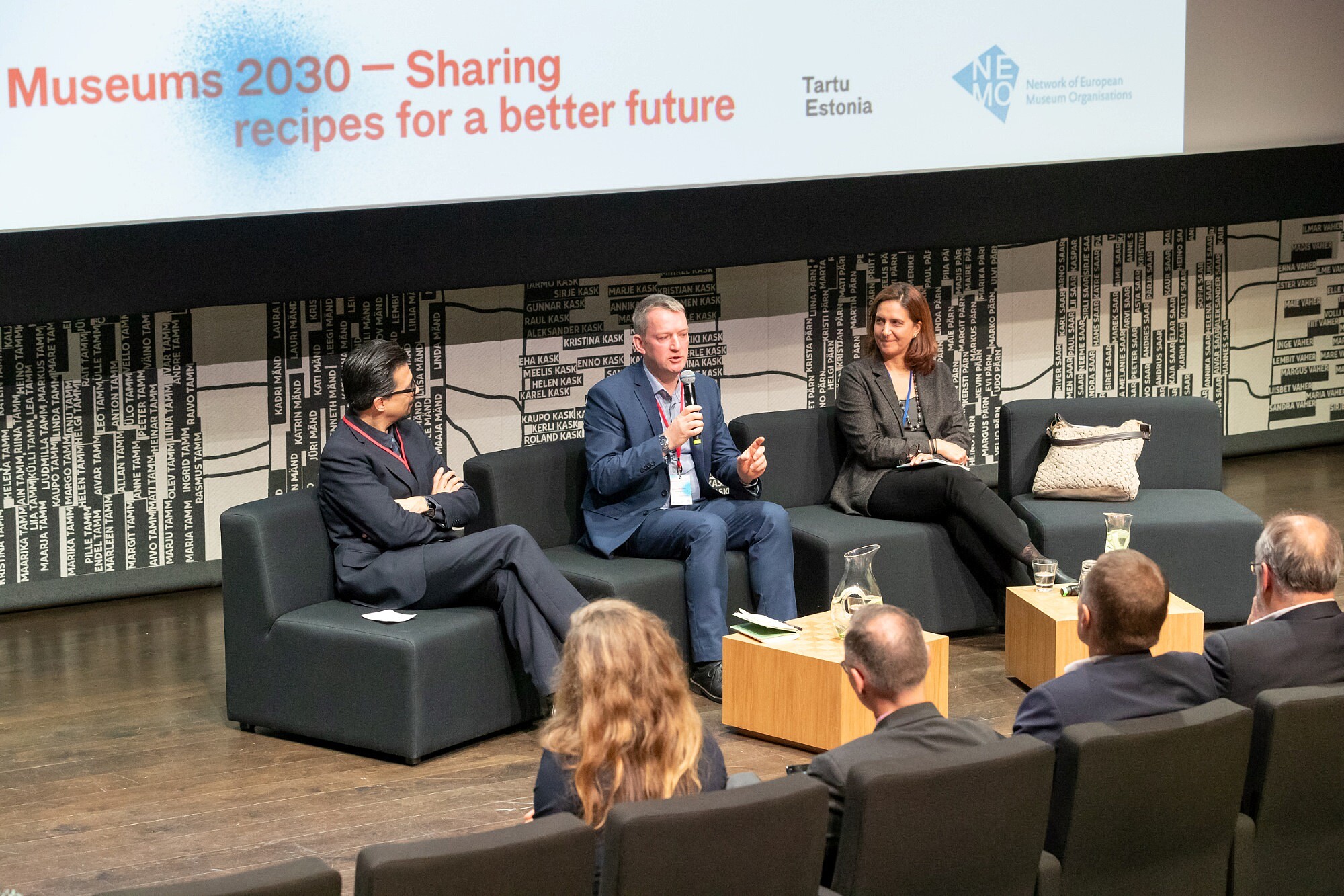 Three people are sitting in arm chairs on a stage and are discussing something.   © Image: Arp Karm